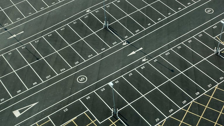 Aerial view of an empty parking lot with numbered spaces in London.