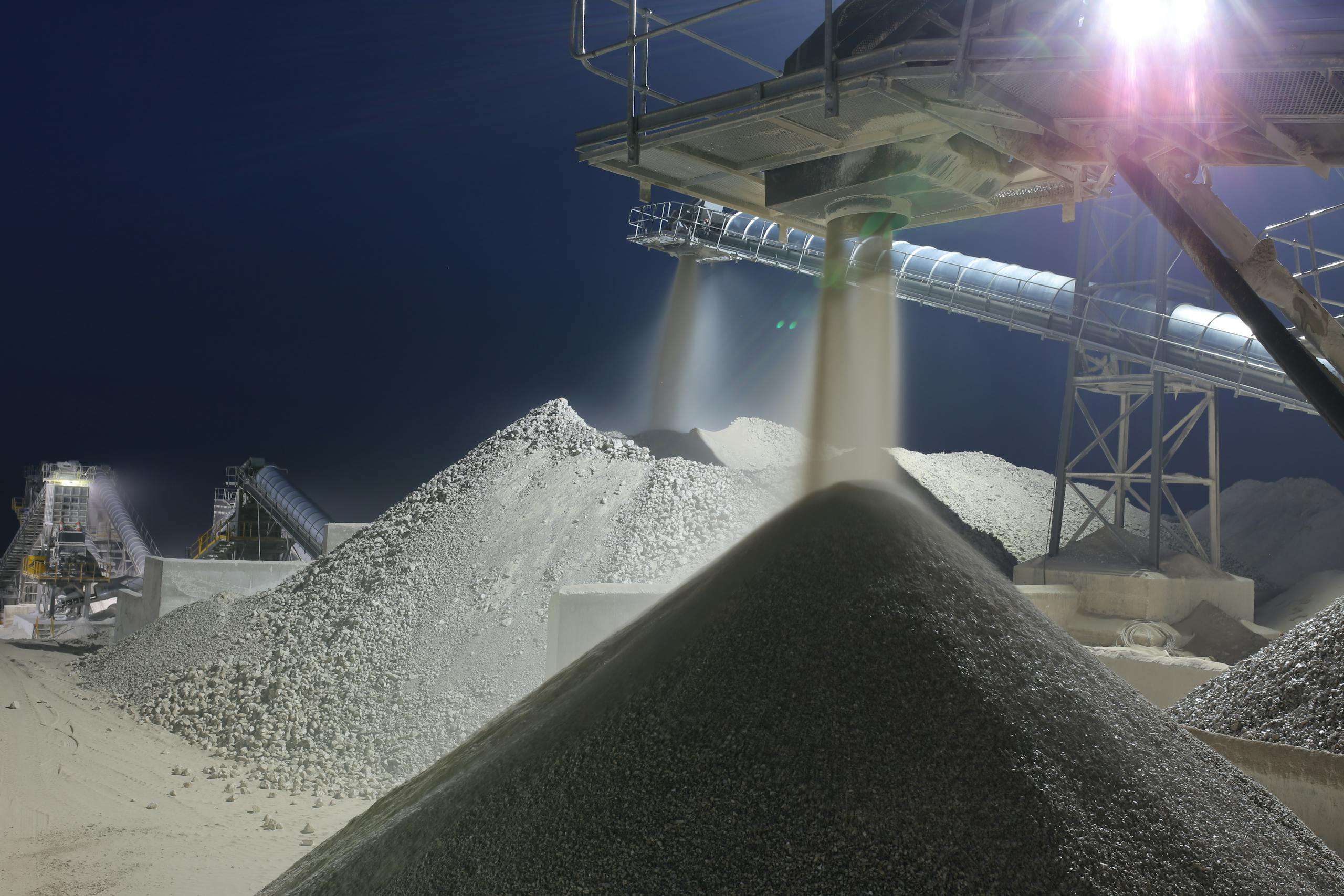 Nighttime industrial sand processing site in Ankara, Turkey with machinery and heaps of sand.